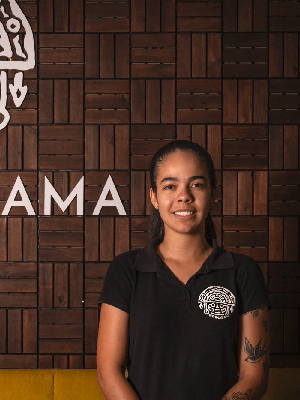 A member of the Pachamama team in front of the carved mask wall