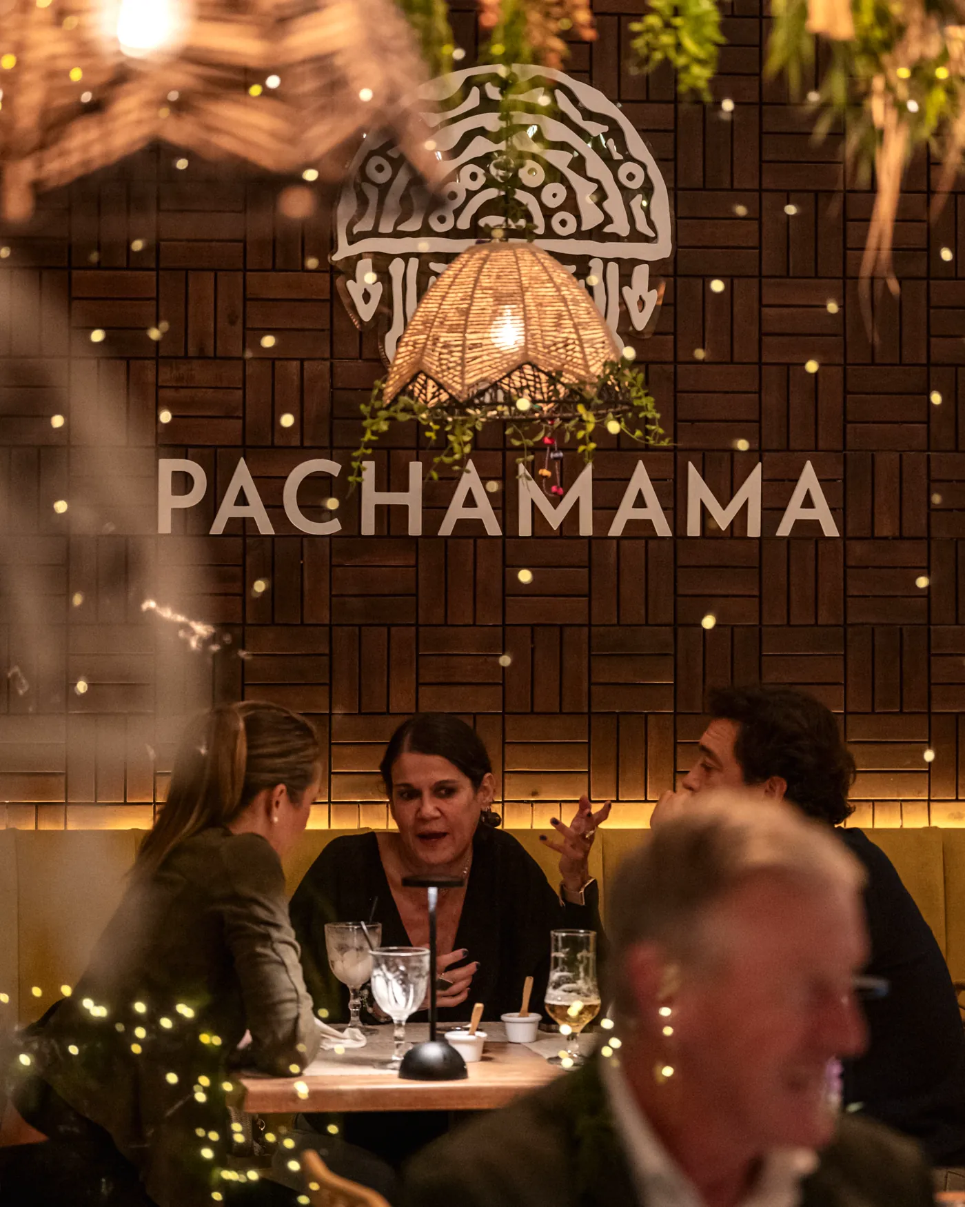A company dinner seated beneath the carved mask wall at Pachamama